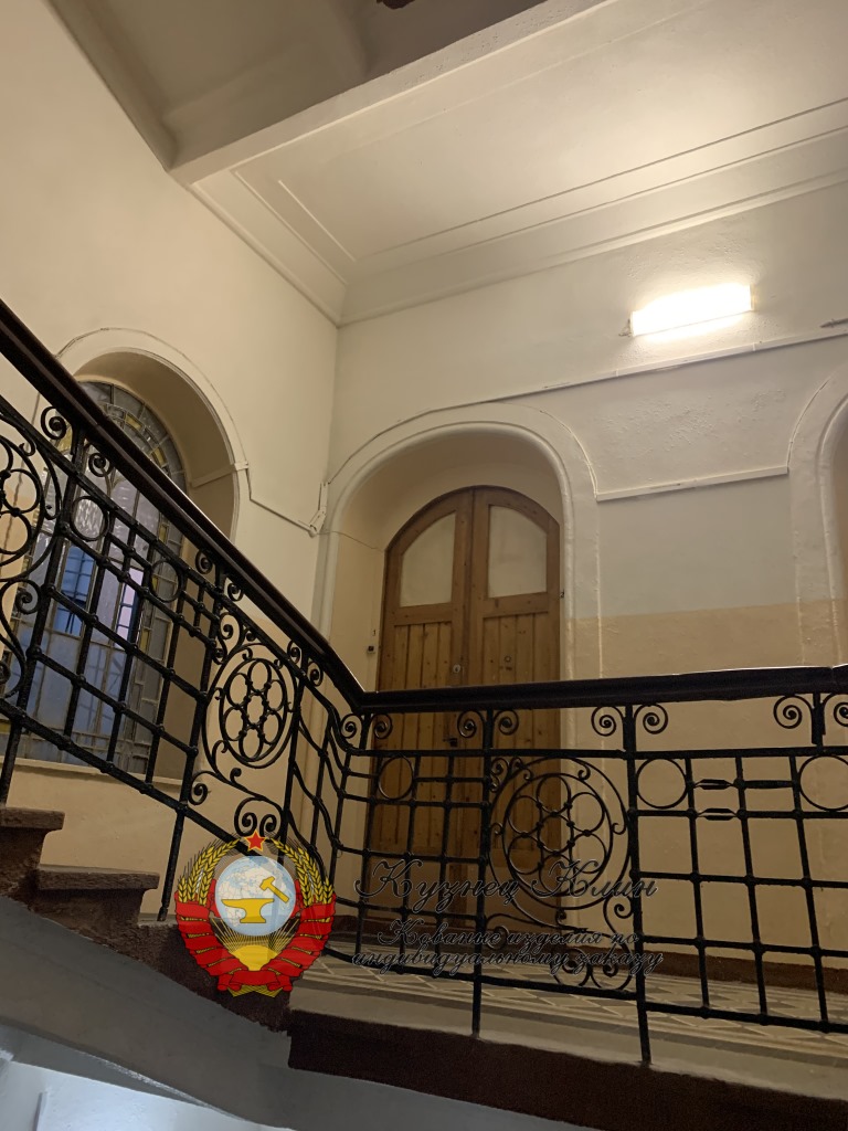 Кованое ограждение лестницы в в стиле модерн с деревянным поручнем